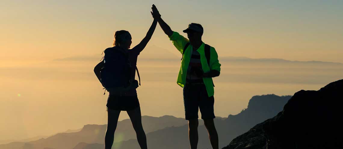 Man and woman celebrating on mountaintop
