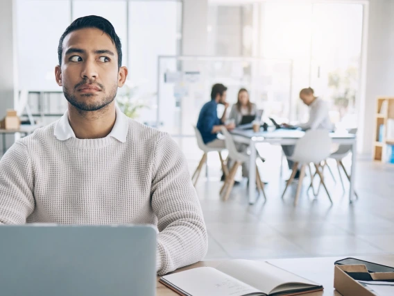 man sitting at computer looking suspicious