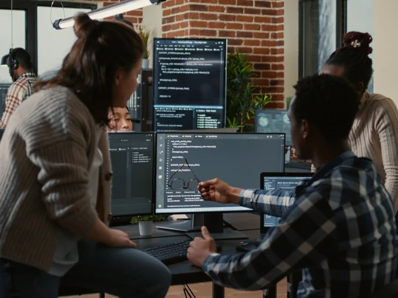 3 people looking at a screen with data