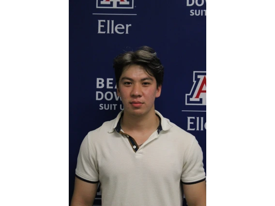 Jakhongir in white collared shirt in front of Eller photo backdrop