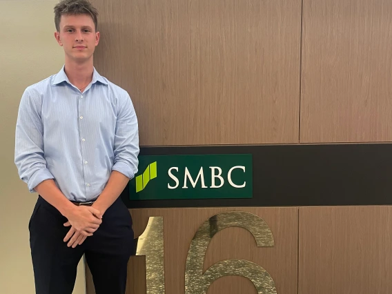 man standing in front of smbc logo