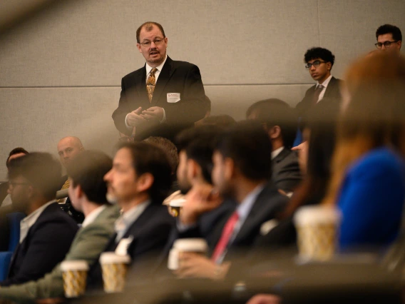 client addresses crowd of graduate students at kickoff event