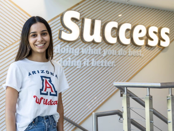 student in front of success sign