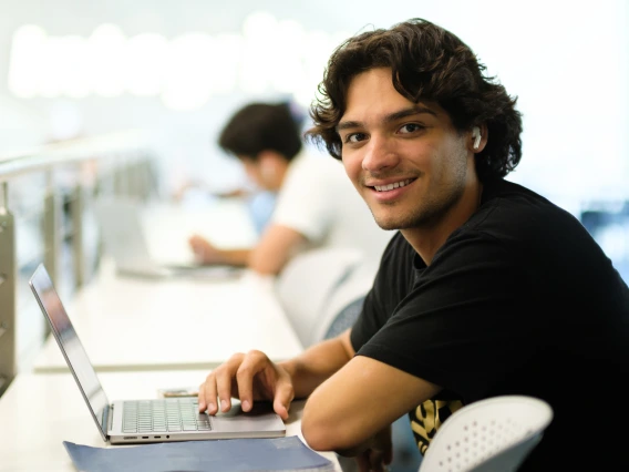 student sitting at desk smiling