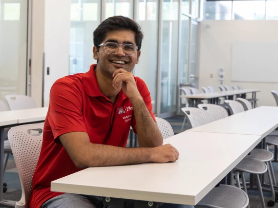 student smiling sitting at a table