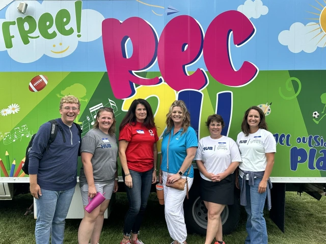 people standing in front of colorful sign