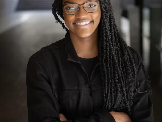 Ashland Johnson standing in a hallway with her arms crossed.