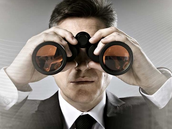 businessman with binoculars in cityscape