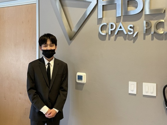 Simon Jeon standing in front of HBL CPAs P.C. metal signage.