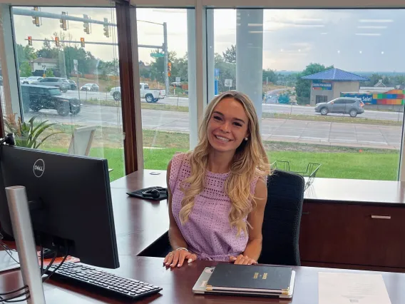 woman sitting at desk in front of big windows