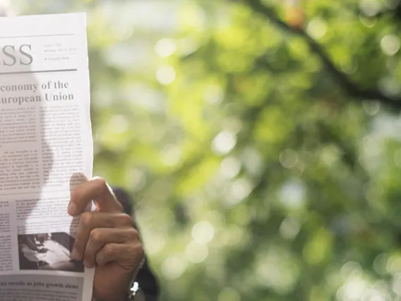 Person reading business section of newspaper