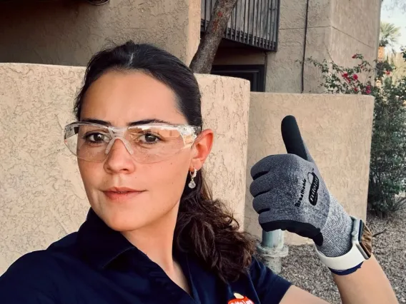 woman wit brown hair in safety goggles giving a thumbs-up 