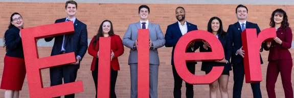 Students standing holding letters spelling Eller