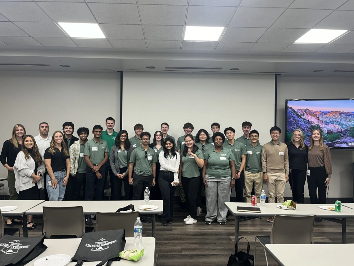 Students wearing green polos and smiling