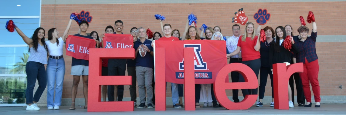 people standing behind Eller letter celebrating