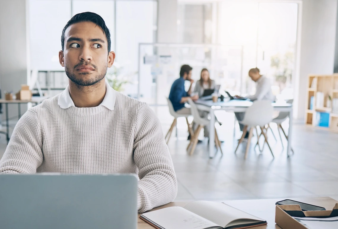 man sitting at computer looking suspicious