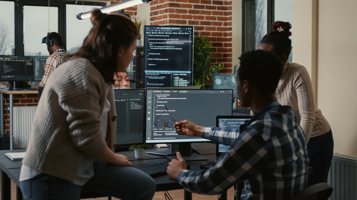 3 people looking at a screen with data