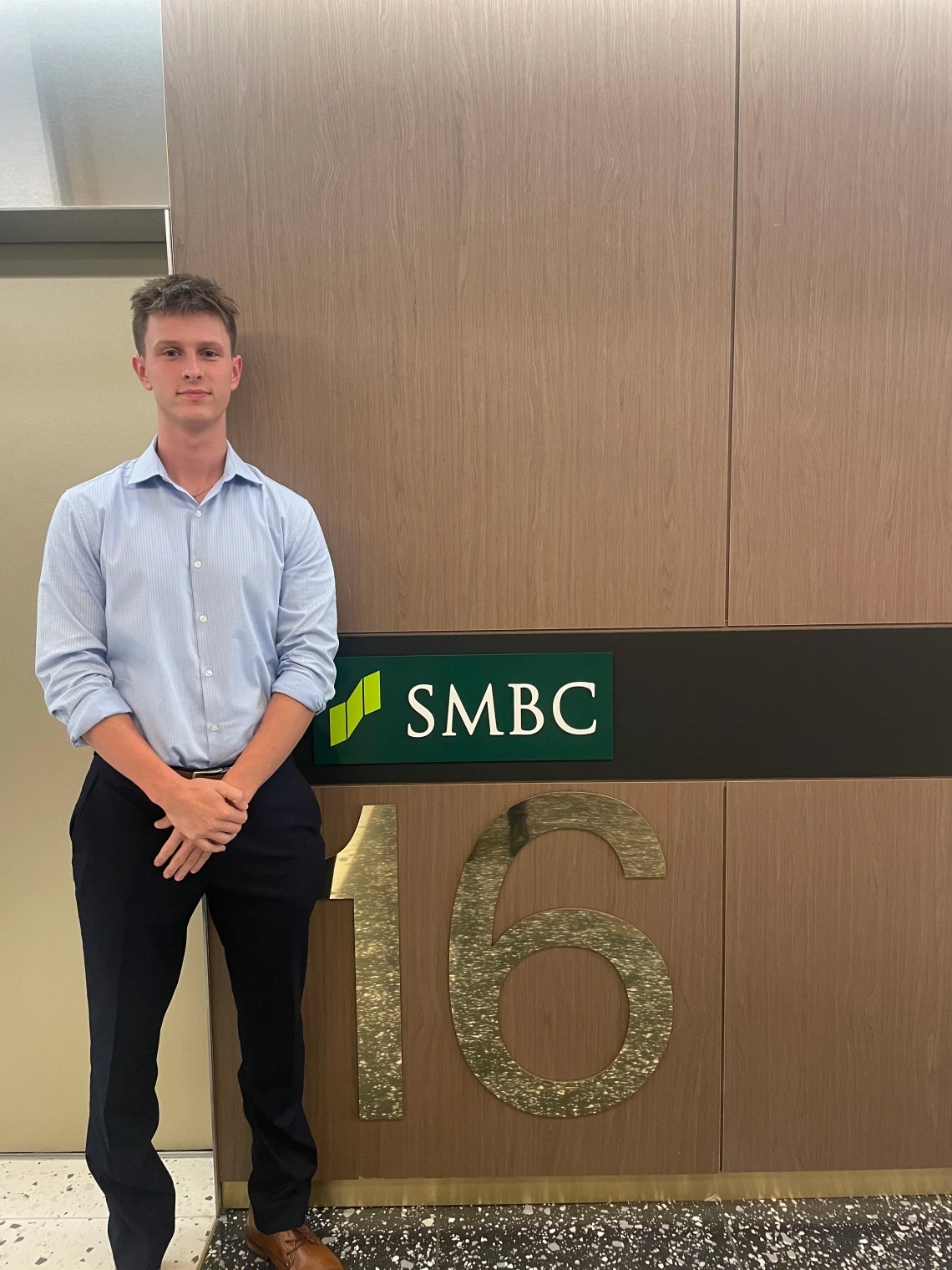 man standing in front of smbc logo