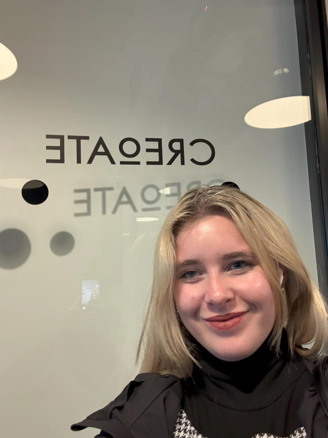 girl in front of logo smiling