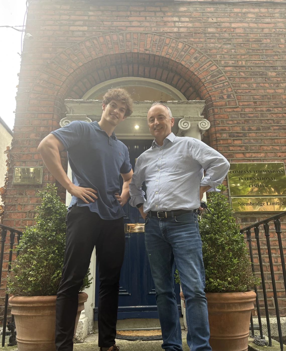 intern in polo standing next to older man