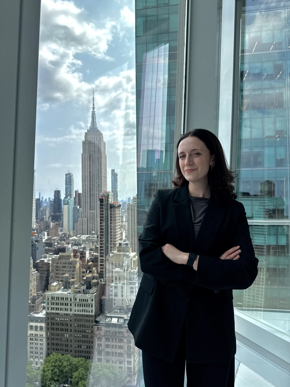 girl in blazer standing in front of empire state building