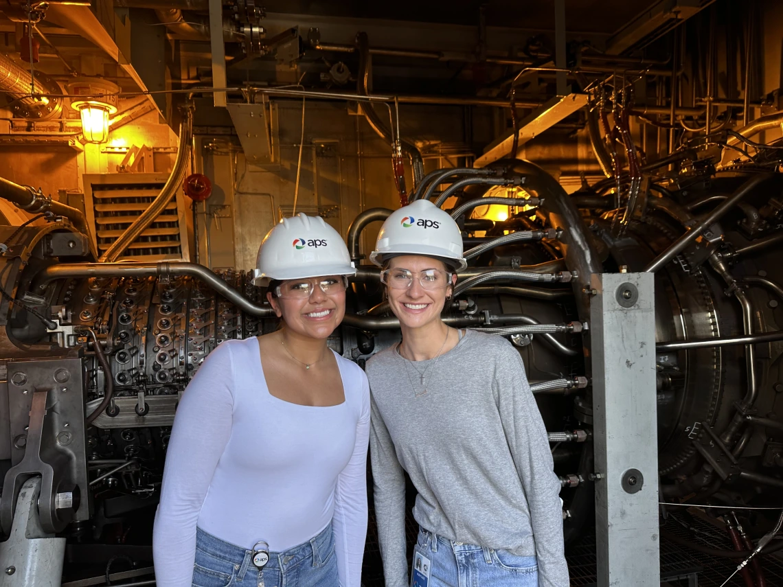 two girls standing with construction hats