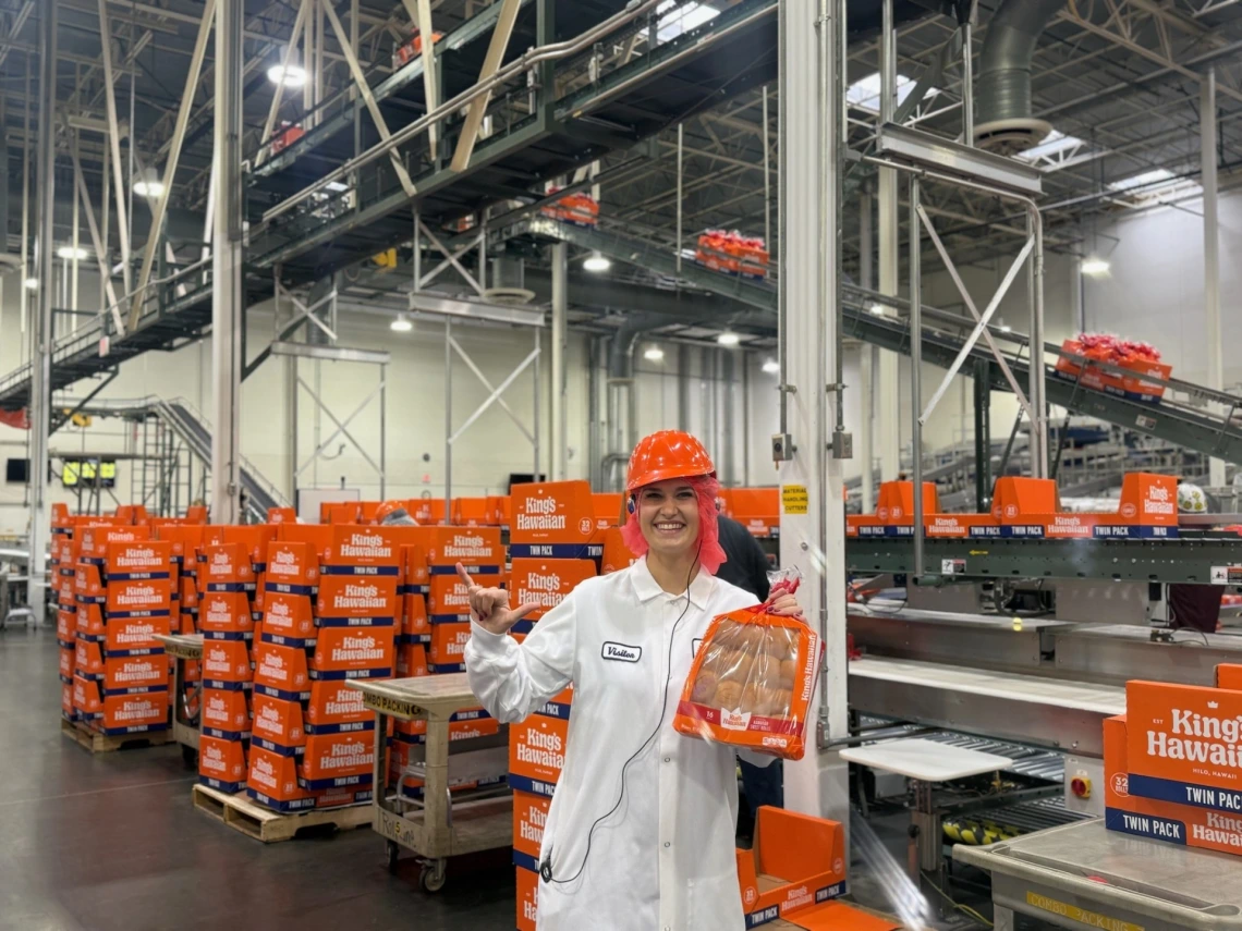 girl standing in white holding food