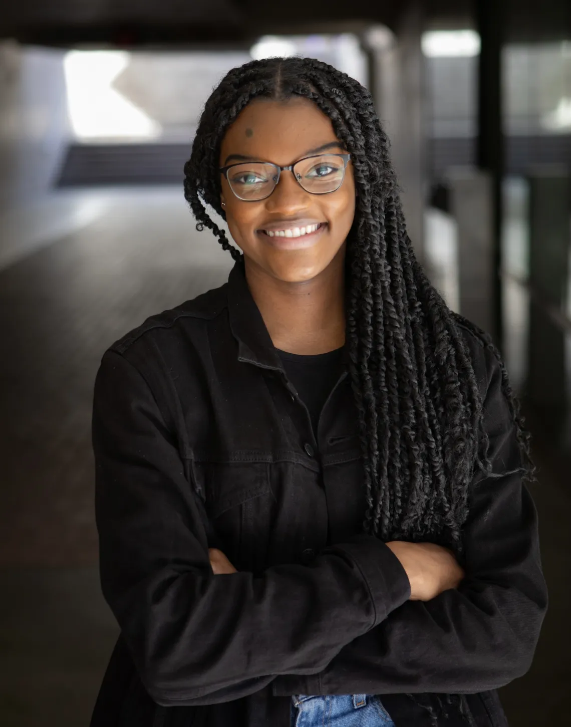 Ashland Johnson standing in a hallway with her arms crossed.