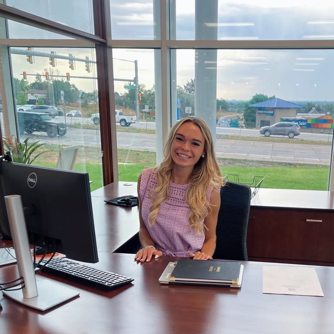 woman sitting at desk in front of big windows