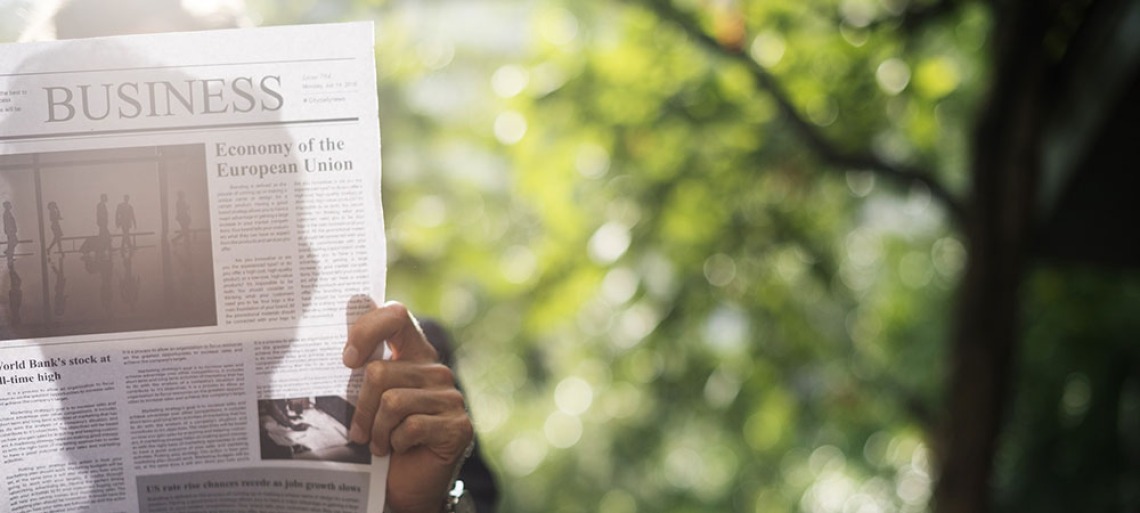 Person reading business section of newspaper