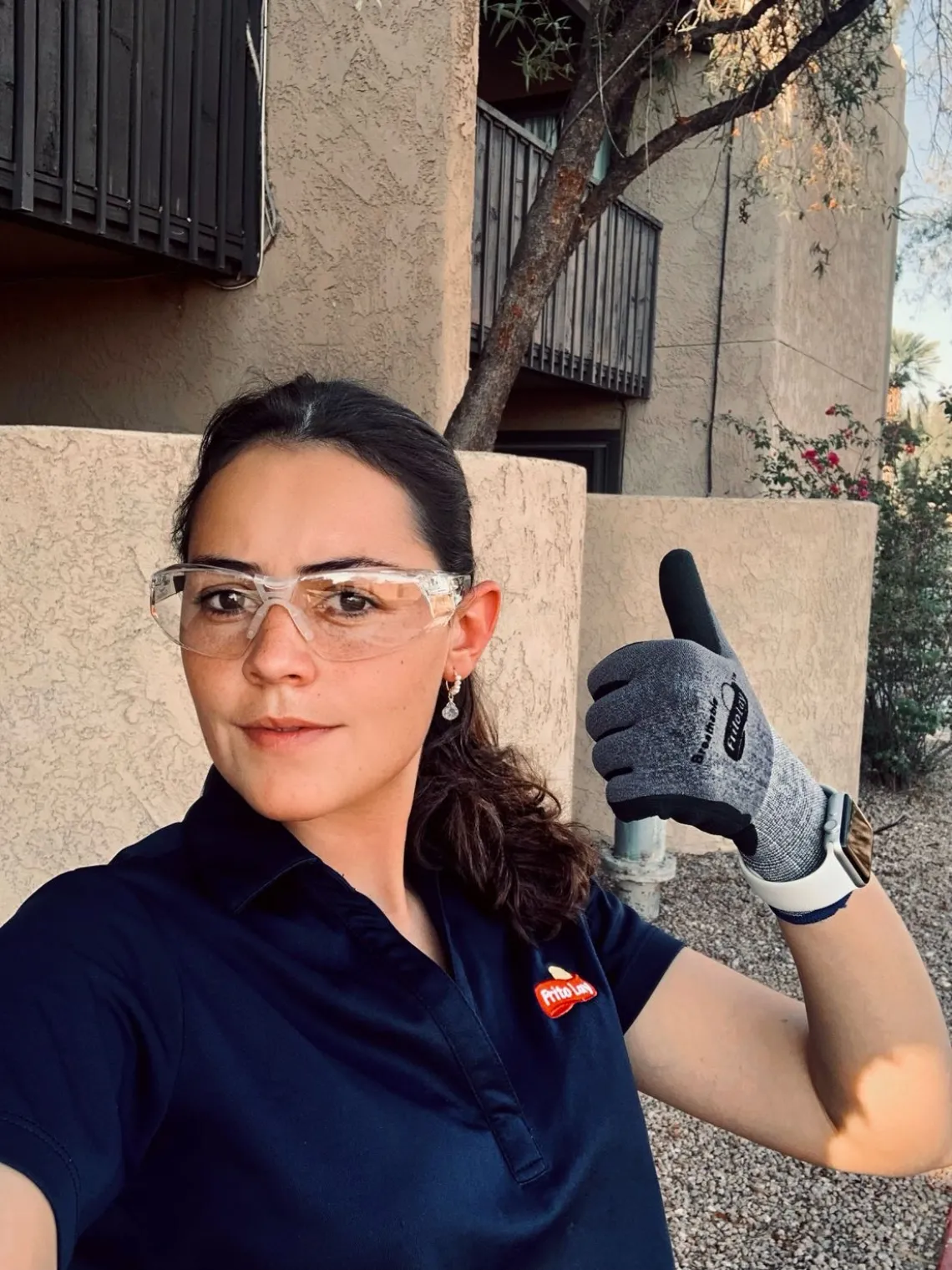 woman wit brown hair in safety goggles giving a thumbs-up 