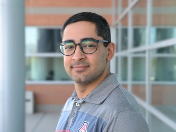 Professor wearing glasses and gray and blue shirt.