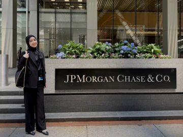 Setora standing in front of JPMorgan Chase & Co building sign; ready for the workday