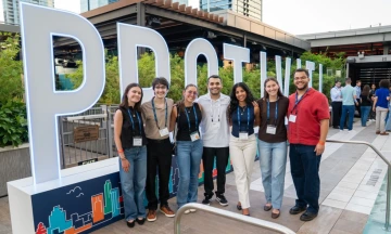 Mackenzie with student group in front of oversized PROTIVITI letters