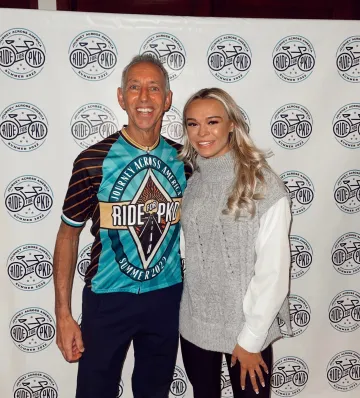 man and woman standing in front of backdrop for RideForPKD