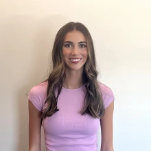 Student smiling wearing a pink shirt