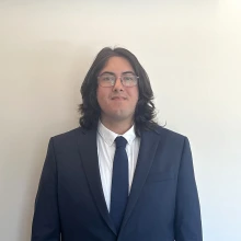 Student smiling wearing a suit and tie