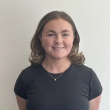 Student wearing a dark gray shirt and smiling