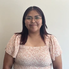 Student wearing glasses and a pink and white shirt