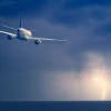 Plane flying lightning ocean
