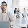 man sitting at computer looking suspicious