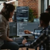 3 people looking at a screen with data