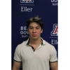 Jakhongir in white collared shirt in front of Eller photo backdrop
