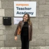 girl standing behind a sign that says "europass teaching academy"
