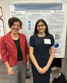 Professor and student standing in front of a poster.