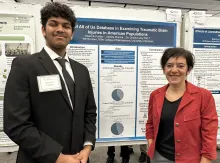 Student and professor standing in front of a poster.