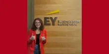 Isa wearing a red blazer and smiling.