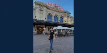 Woman with brown hair smiling standing in front of the union station.