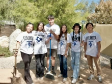 group of students posing for photo outside after volunteering. shirts say "live united"