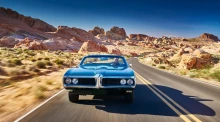 Man driving car desert road